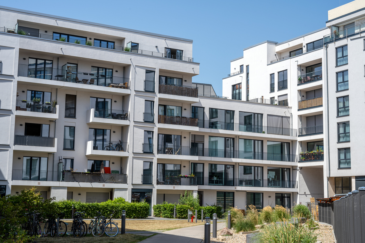 Résidence collective récente aux façades isolées, vue depuis les espaces verts communs