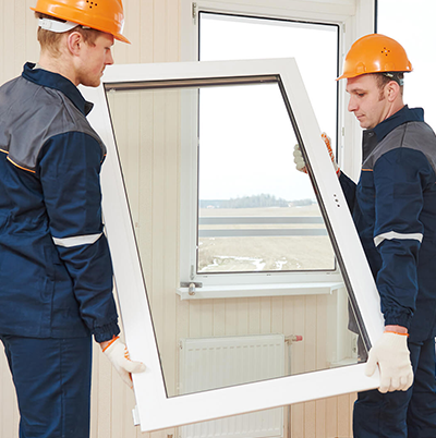 Pose d'une fenêtre à double vitrage par deux installateurs