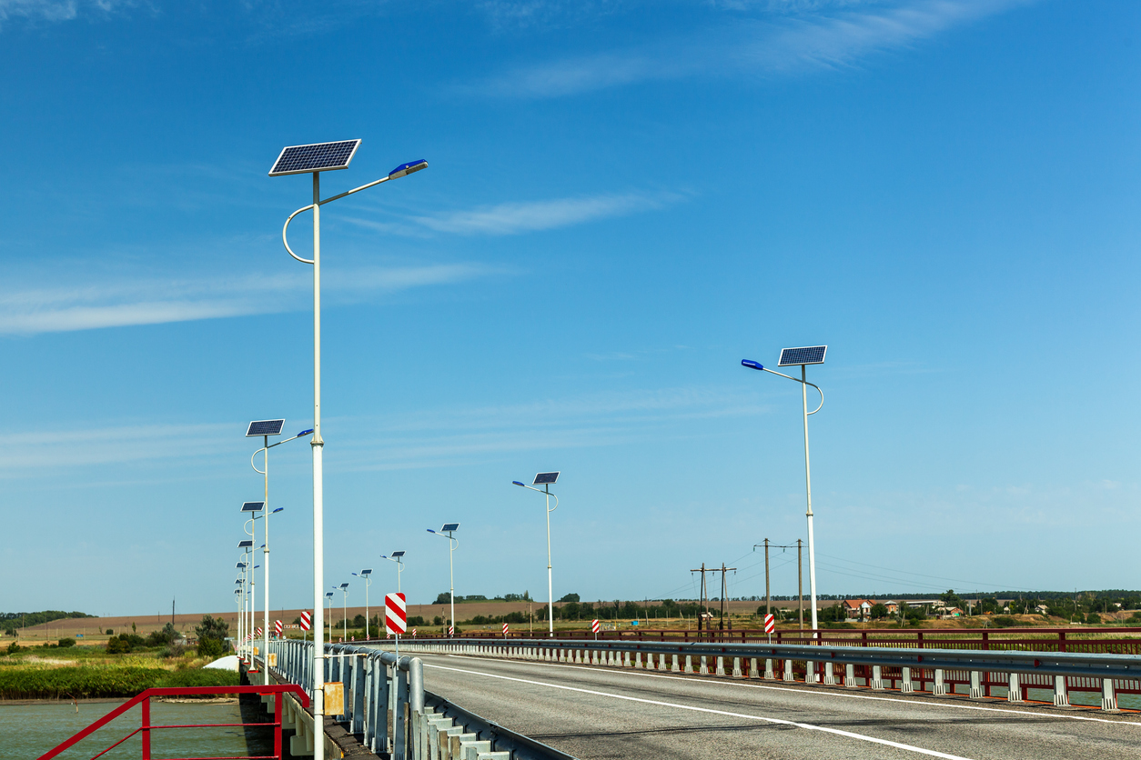 Lampadaires solaires autonomes installés le long d'un pont routier au-dessus d'un plan d'eau