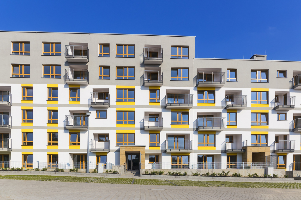 Longue façade enduite blanche et jaune après isolation thermique par l'extérieur