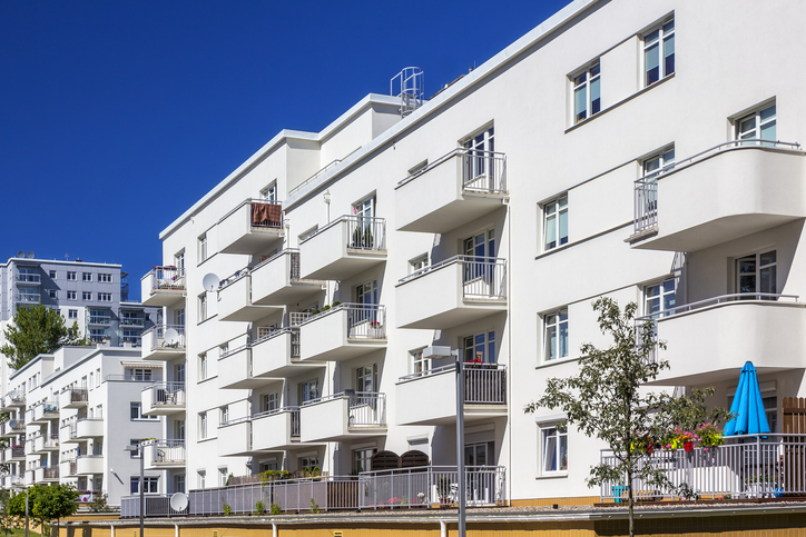 Immeuble d'habitation blanc avec balcons, façade ravalée après isolation thermique par l'extérieur