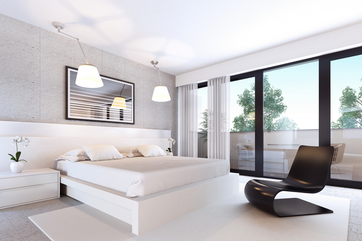 Chambre contemporaine ouverte sur un balcon par une porte-fenêtre coulissante à cadre noir