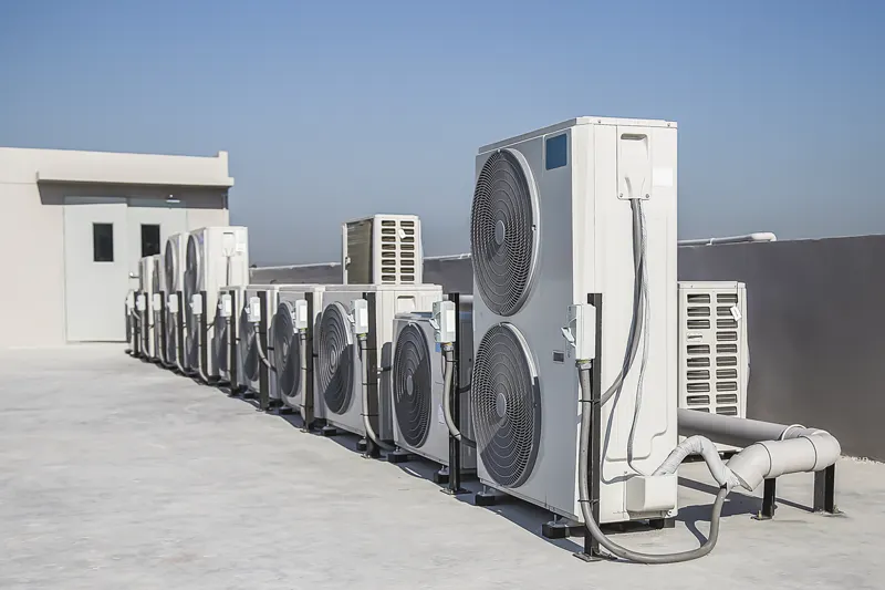 Groupes extérieurs alignés en toiture d’immeuble — climatisation réversible immeuble d’habitation dans le Grand Est