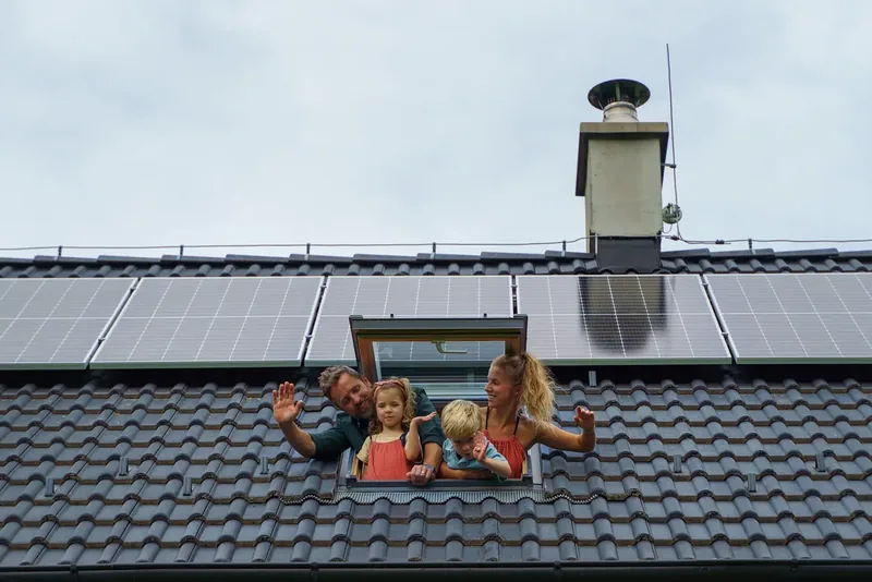 Famille à la fenêtre de toiture d'une maison — France
