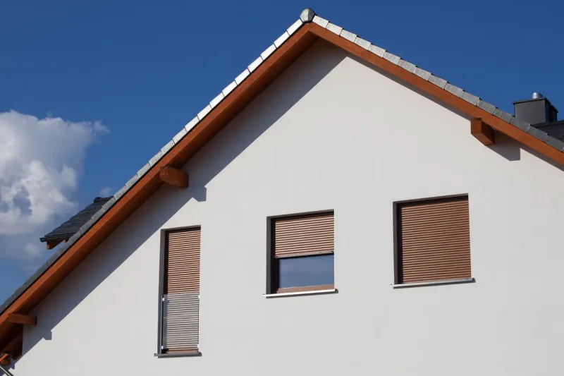 Volets roulants bruns sur un pignon de maison — France