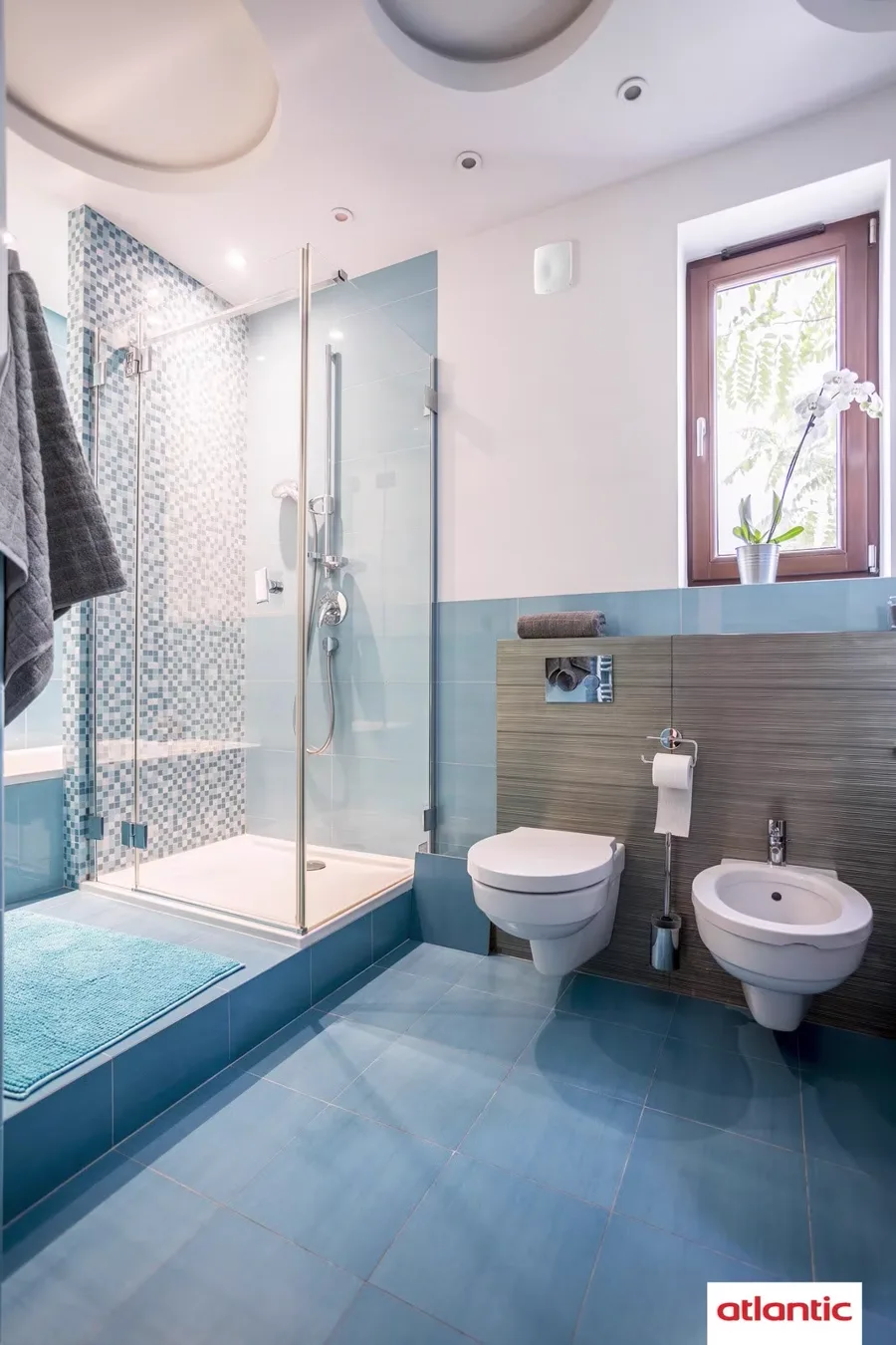 Salle de bain équipée d'un aérateur individuel mural au-dessus de la douche
