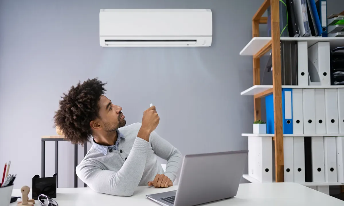 Unité murale de climatisation réversible pilotée par télécommande dans un bureau